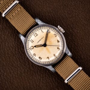 Vintage Longines caliber 12L field watch, cream dial with luminous Arabic numerals, on a khaki nylon strap