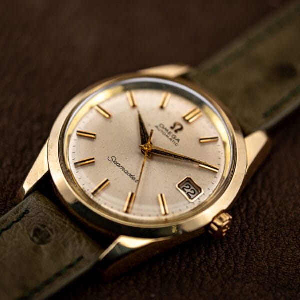 Close three-quarter angle on the 166.010 dial, applied gold batons and the framed date window at three