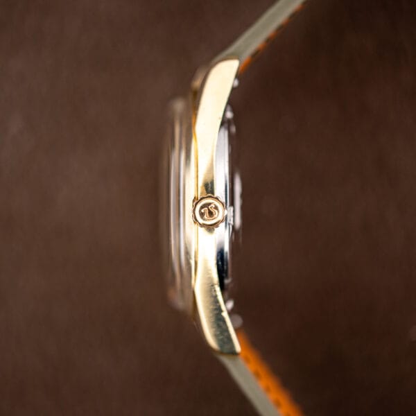 Fluted crown signed with the Omega symbol, gold capped case sitting above the stainless steel back