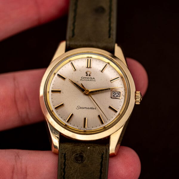 In hand front view of the 166.010, fluted crown, Seamaster script and SWISS MADE both readable