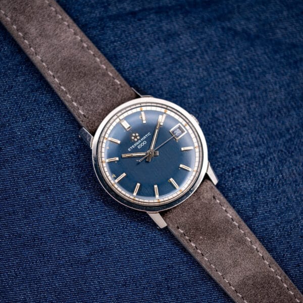 Close detail of applied faceted baton markers and creamy aged lume on the blue Eterna 1000 dial.