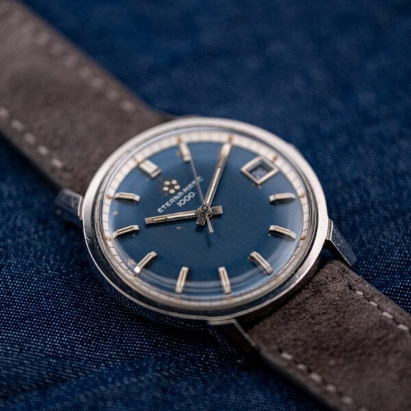 Eterna-Matic 1000 tilted to show the domed acrylic crystal and faceted lugs of the stainless case.