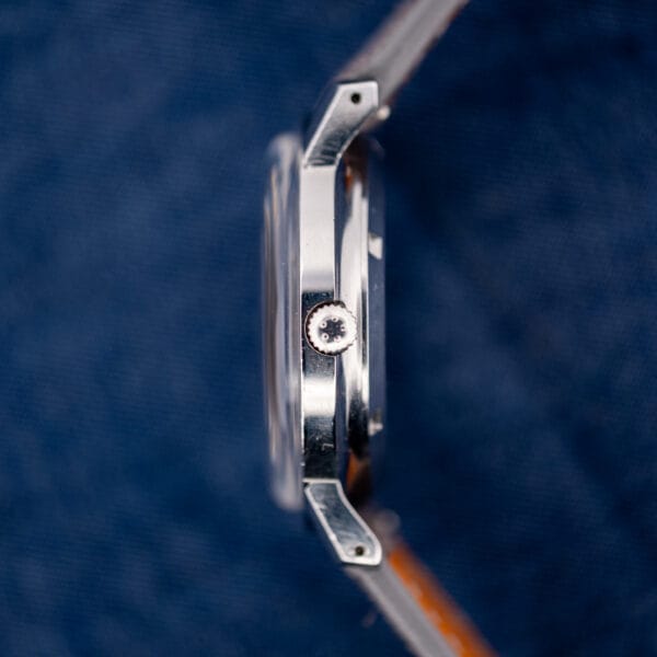 Side profile of the Eterna-Matic 1000 showing the signed fluted crown and grey Italian suede strap.
