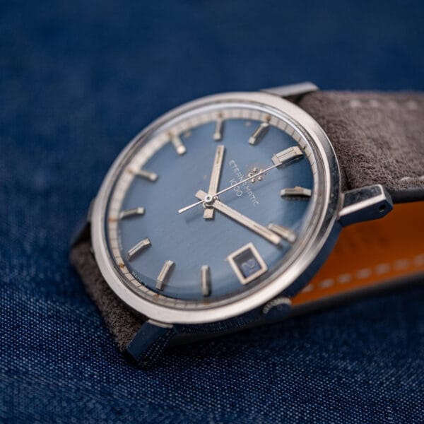 Vintage Eterna 1000 dial shifting to bright steel blue in raking light, date showing at three.
