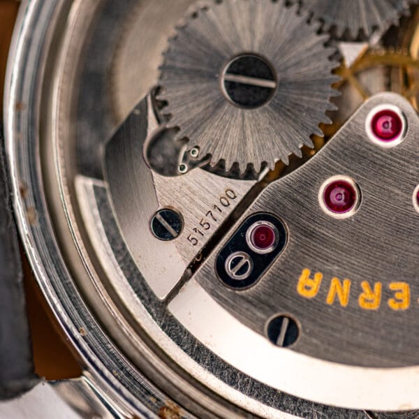 Movement macro showing ruby jewels in polished settings and the movement serial 5157100 engraved on the bridge.