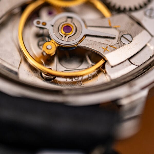 Macro of the shock-protected gilt balance and the caliber engraving on the mainplate.