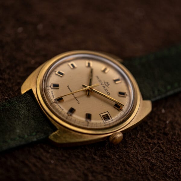 Low angle on the Movado Sub-Sea champagne dial, gold baton hands sweeping over applied markers