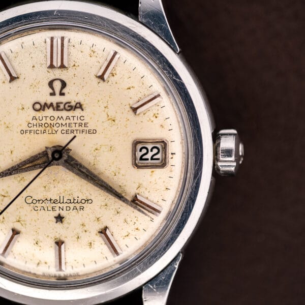 Close macro of the Omega 2943-2 stepped date frame at three beside the signed crown