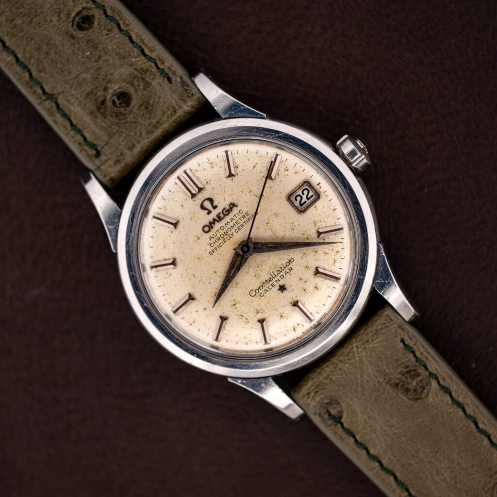 Omega Constellation 2943-2 top down on olive ostrich strap, off-white speckled dial with date at three