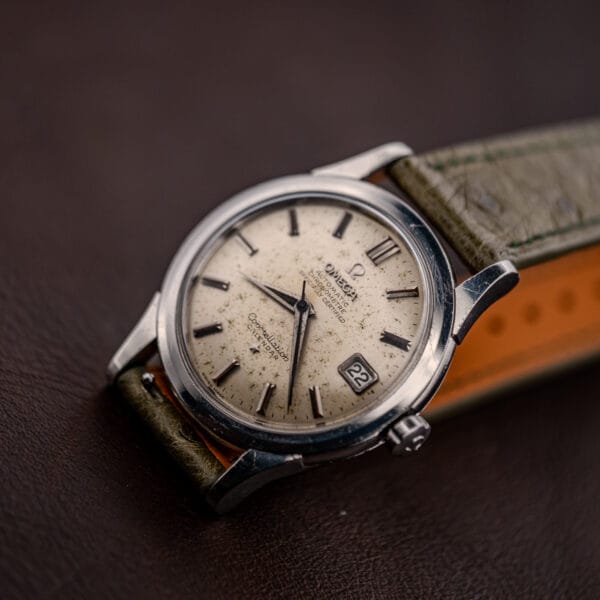 Three-quarter view of the vintage Omega Constellation Calendar, olive ostrich strap showing its tan leather lining