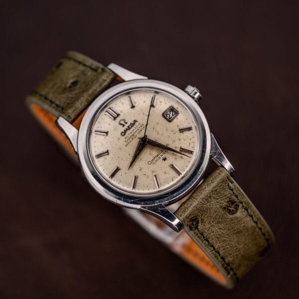 Omega Constellation 2943-2 shot from above at an angle, off-white dial and olive ostrich strap