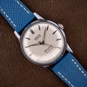 Vintage Gruen Precision Autowind with a silvered white dial on a blue leather strap, shown face-up.