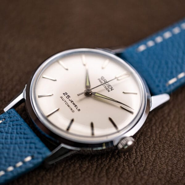 Raking light across the Gruen dial catching the applied markers, dauphine handset and thin sweep seconds.