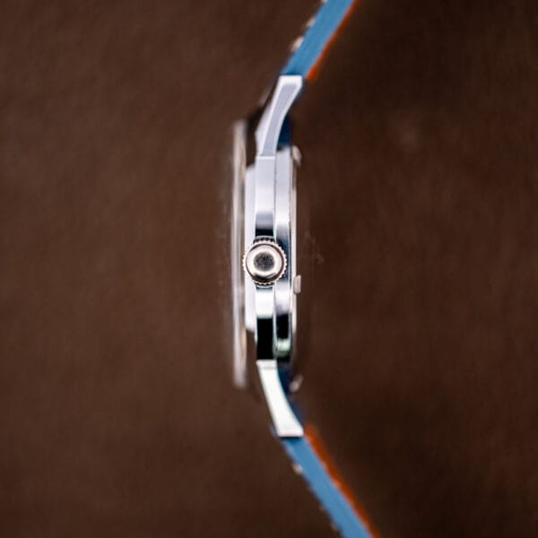 Side profile of the Gruen case showing the signed crown and slim mid-century case band.