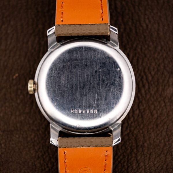 Eterna caseback exterior stamped 3107700, brushed finish carrying honest hairlines from decades of wrist wear