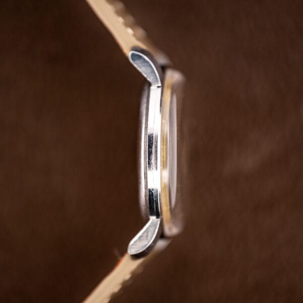 Side view of vintage Eterna dress watch, domed acrylic crystal standing proud of the polished case band
