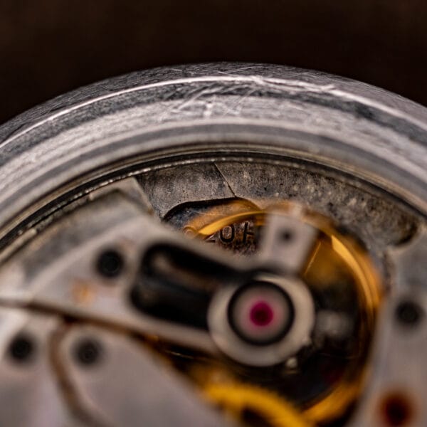Extreme macro inside vintage Eterna showing polished case rim, jeweled balance and gilt train wheels