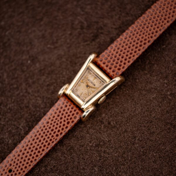 Full front view of the LeCoultre Aristocrat, tapered gold filled case with sculptural splayed grasshopper lugs.