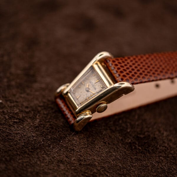Three quarter view of the LeCoultre Aristocrat on brown lizard strap, asymmetric grasshopper case in gold filled.