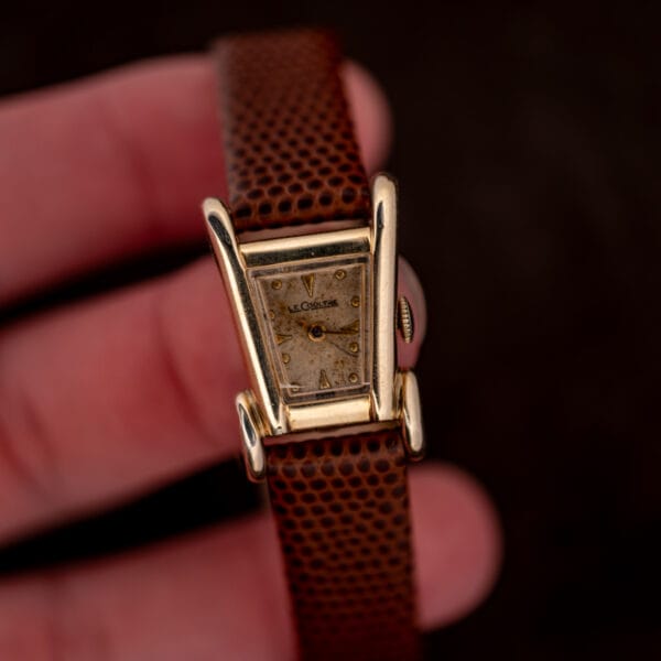 In hand view of the LeCoultre Aristocrat, signed dial reading LeCoultre and Swiss above the tapered case.