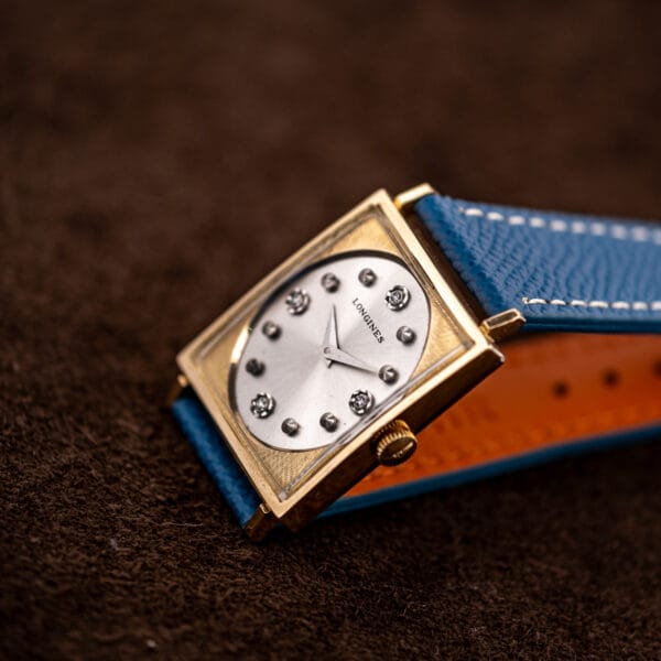 Longines Tank 3217-428 angled with diamond markers catching light across the recessed silver starburst dial