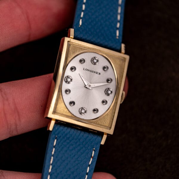 Longines Tank 3217-428 held in hand, four diamonds at the quarters and eight polished studs between