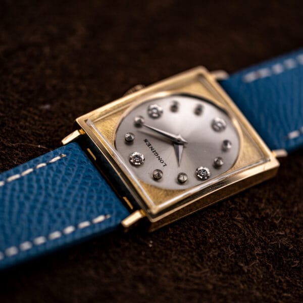 Longines Tank 3217-428 angled study, dauphine hands over silver dial framed by textured gold filled case