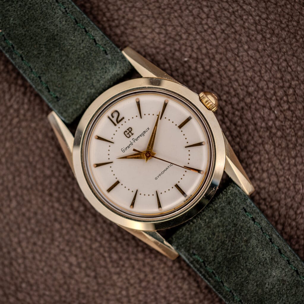 Vintage Girard-Perregaux Gyromatic white dial with applied gold batons and dauphine hands on forest green suede strap