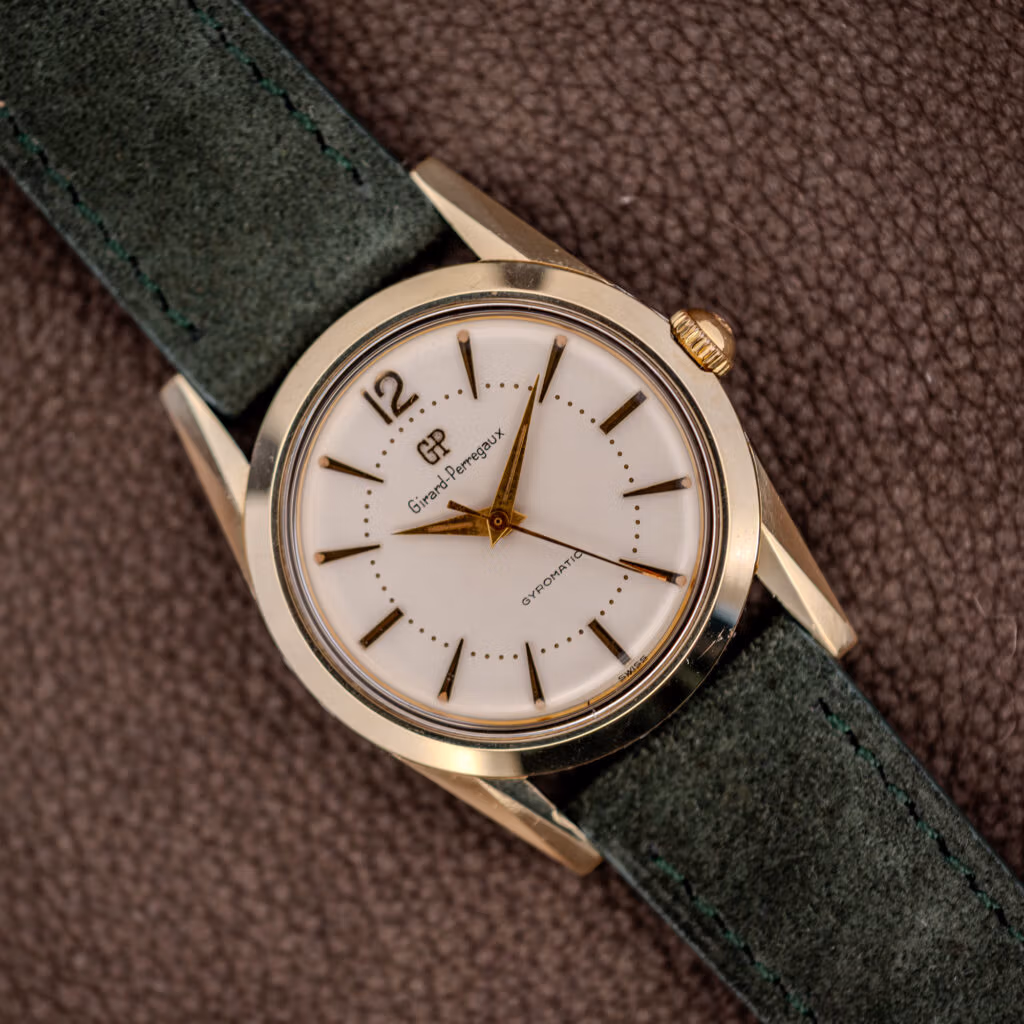 Vintage Girard-Perregaux Gyromatic white dial with applied gold batons and dauphine hands on forest green suede strap