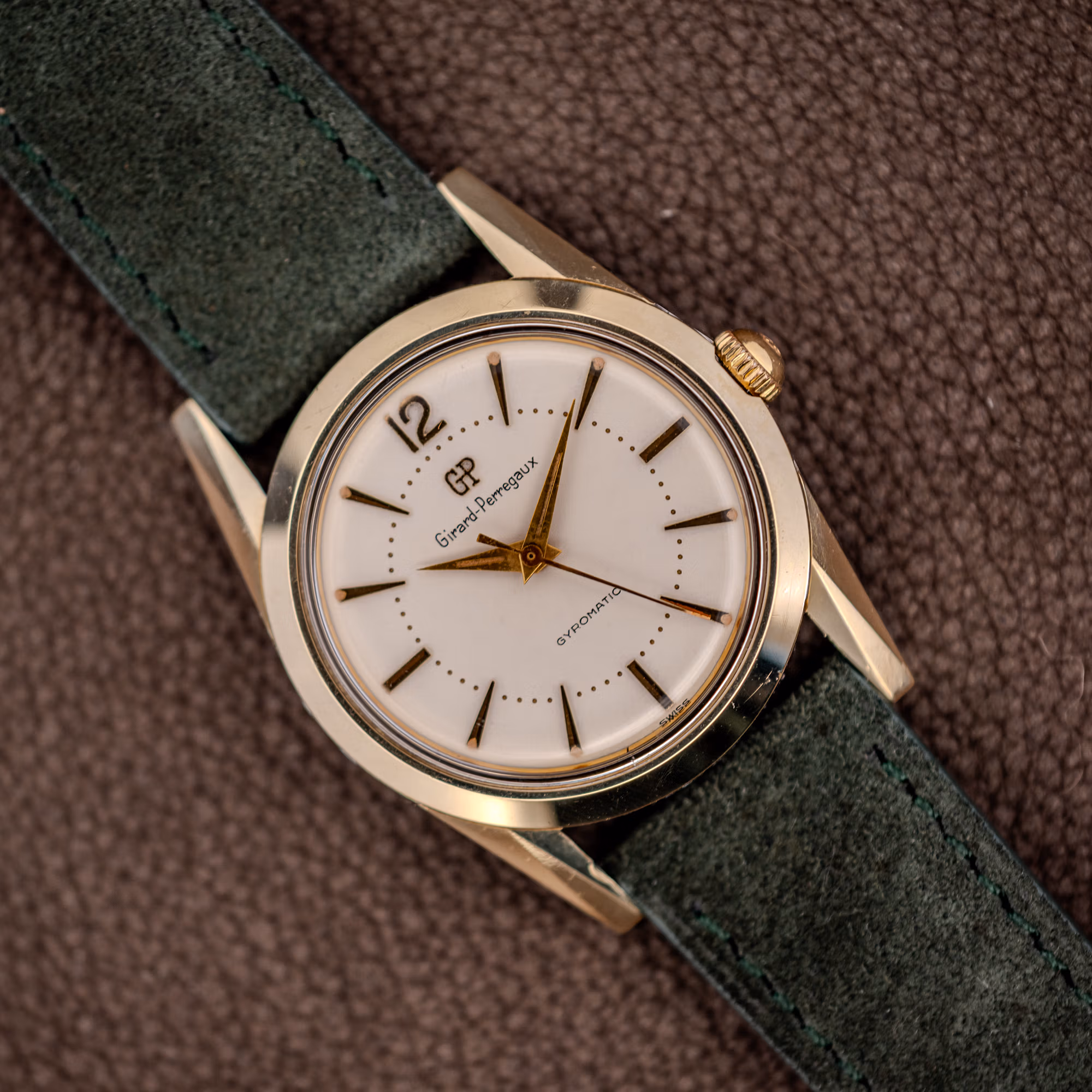 Vintage Girard-Perregaux Gyromatic white dial with applied gold batons and dauphine hands on forest green suede strap