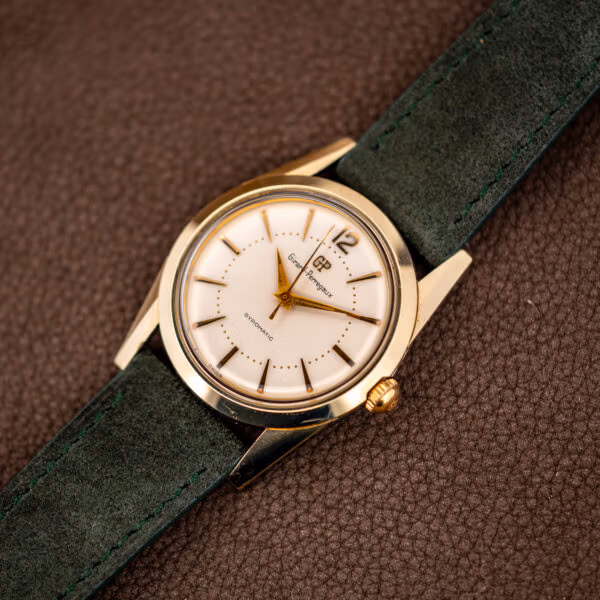 Vintage Girard-Perregaux Gyromatic 33mm gold capped case angled on a forest green Italian suede strap