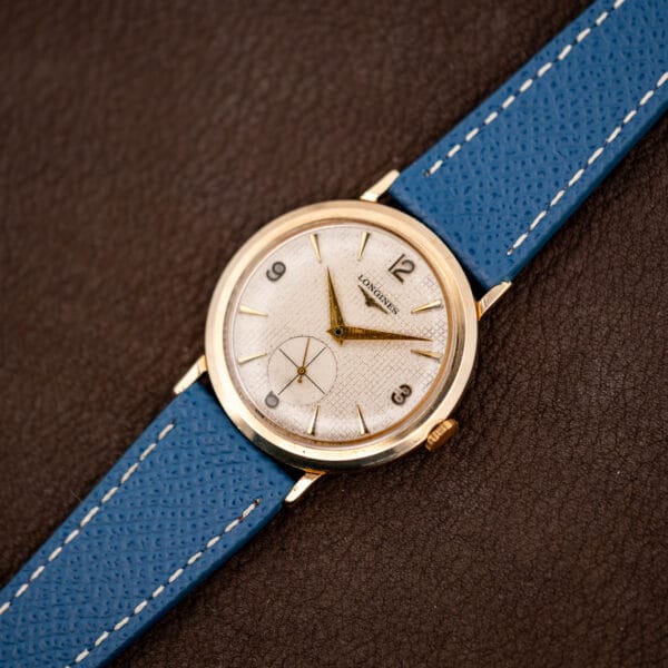 Vintage Longines 1044 angled on brown leather, gold filled case with domed crystal and flared lugs