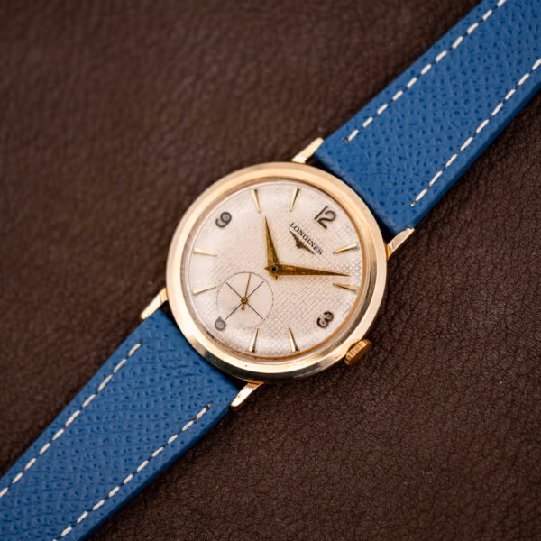 Vintage Longines 1044 angled on brown leather, gold filled case with domed crystal and flared lugs
