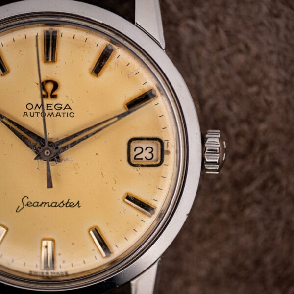 Omega Seamaster 14760 aged eggshell dial close-up, framed date window at three showing 23 beside the fluted crown