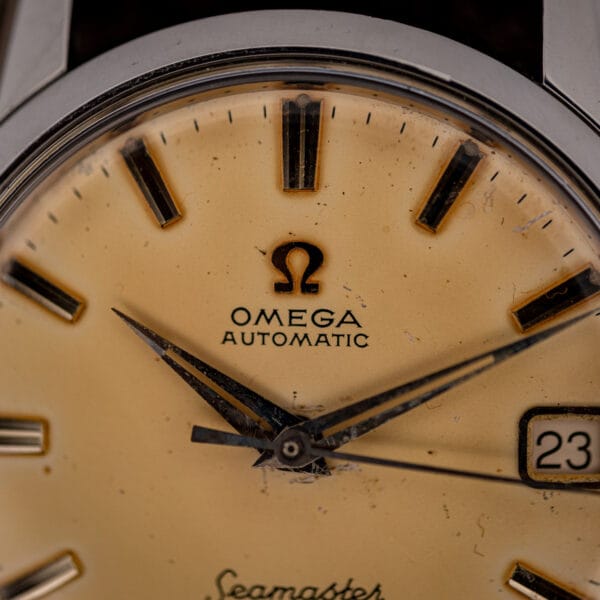 Macro of Omega Seamaster 14760 dial showing the applied Omega symbol, OMEGA AUTOMATIC printing and faceted dauphine hands