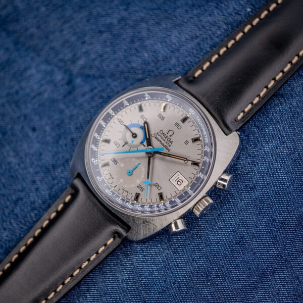 Vintage Omega Seamaster 176.007 chronograph angled on indigo denim showing cushion case and blue tachymetre ring