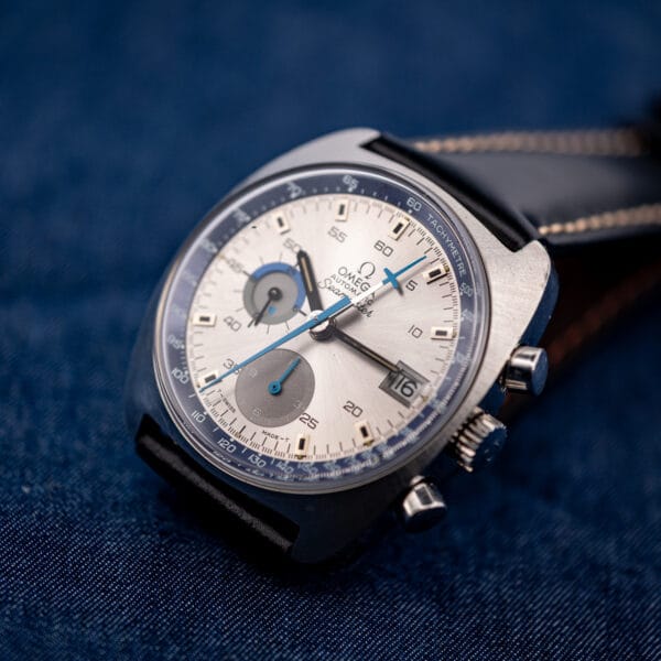 Omega Seamaster 176.007 chronograph angled on denim with black leather strap and blue accented silver dial