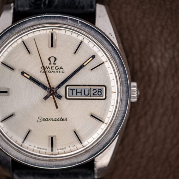 Omega Seamaster 166.032 dial angled to catch light across the brushed steel bezel and signed crown
