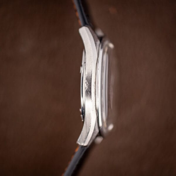 Side profile of the Omega Seamaster 166.032 stainless case showing downturned faceted lugs and domed crystal