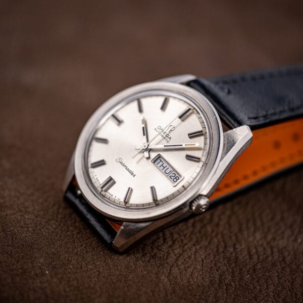 Omega Seamaster 166.032 angled on its black ostrich strap, tan lining visible beneath the leather