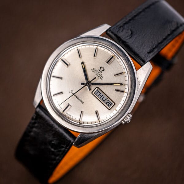 Vintage Omega Seamaster 166.032 day-date automatic viewed from above with the strap curled beside it