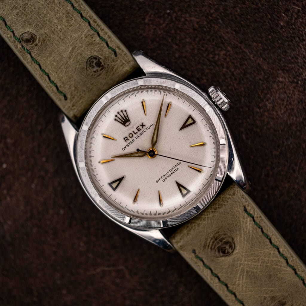 Rolex Oyster Perpetual 6085 white chronometer dial with applied gold markers on an olive ostrich strap