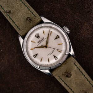 Rolex Oyster Perpetual 6085 white chronometer dial with applied gold markers on an olive ostrich strap