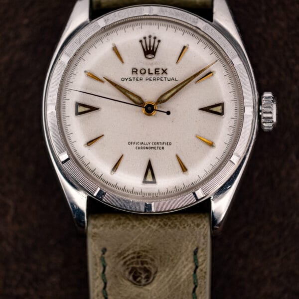Straight on dial macro of the Rolex Oyster Perpetual 6085 showing tapered gold darts and dauphine hands