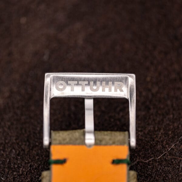 OTTUHR signed steel buckle on the olive green ostrich strap with tan lining and green stitching