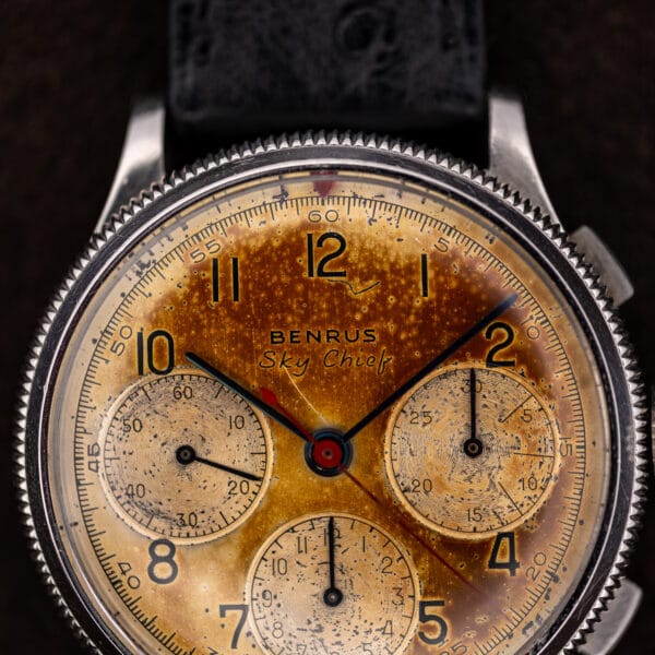 Benrus Sky Chief dial macro, black printed signature over a deep tobacco-brown center bloom