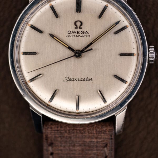Macro of the Omega 165.002 brushed silver dial, no date window, dial foot reading SWISS MADE T