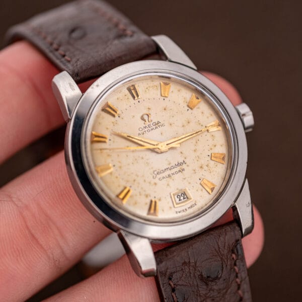 Omega Seamaster Calendar dial close-up showing starburst patina freckles across the aged eggshell surface