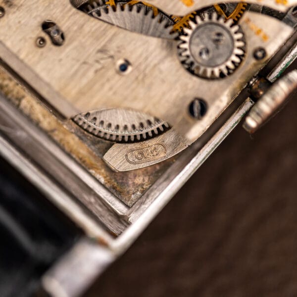 Macro of Gruen Curvex movement corner with caliber 370 stamped in an oval cartouche beside the ratchet wheel
