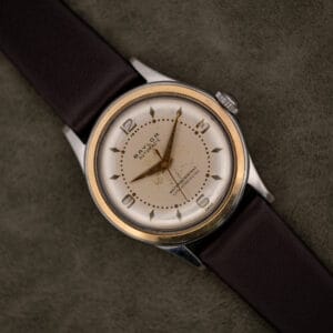 Vintage Baylor Automatic cream dial with applied gilt numerals and yellow bezel ring on a leather strap